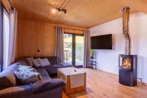 a living room with a couch and a fireplace at Almdorf Hohentauern by ALPS RESORTS in Hohentauern +42 photos