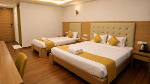 a hotel room with two beds in a room at Hotel Lemon in Valavanūr