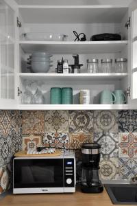 a microwave sitting on a counter in a kitchen at Samothrakis Michelangelo 401 in Samothraki +15 photos