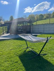 a hammock in a yard with a gazebo at 3 JASKÓŁKI in Kasina Wielka