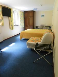 una habitación de hotel con 2 camas y una silla en Hôtel du Fort, en Huy