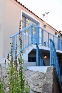a house with blue railings and stairs next to a building at Samothrakis Michelangelo 401 in Samothraki