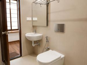a bathroom with a toilet and a sink at Hotel Lemon in Valavanūr
