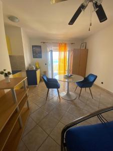 a living room with a table and blue chairs at Apartments Natali in Sveti Petar