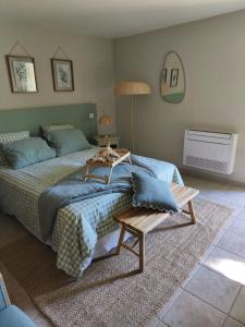 a bedroom with a large bed and a table at Le Castelas - Hébergement complet in Aurons +43 photos