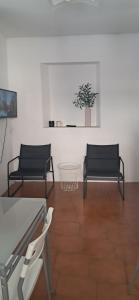 two black chairs and a table in a room at Casa Olivia in Margno