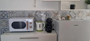 a kitchen counter with a microwave and a refrigerator at Casa Olivia in Margno
