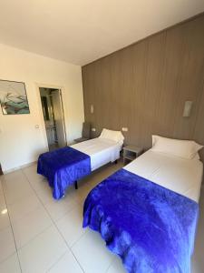 two beds in a hotel room with blue sheets at Hotel Niza in Salou