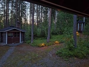 a small cabin in the middle of a forest with lights at Honkala Cottage in Keyritty