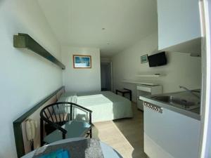 a small room with a bed and a kitchen at Studio piscine et vue mer in Trévou-Tréguignec