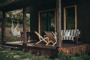 a porch of a house with chairs and a hammock at Mech i brzoza in Baligród