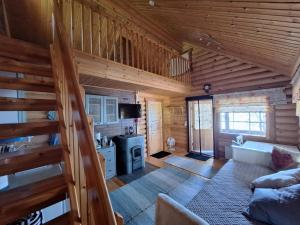 a living room with a staircase in a log cabin at Honkala Cottage in Keyritty
