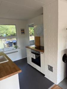 a kitchen with a sink and a stove top oven at Sommerhus i Hals in Hals