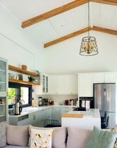 a kitchen with white cabinets and a couch at Villa Ada Bohème in Muğla