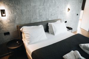 a bedroom with a bed with white sheets and pillows at Vicanto A frame Bucovina in Gura Humorului +91 photos
