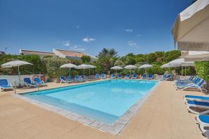 a large swimming pool with chairs and umbrellas at Résidence Odalys Aqualia in Balaruc-les-Bains