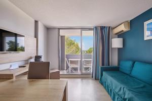 a living room with a blue couch and a table at Résidence Odalys Aqualia in Balaruc-les-Bains