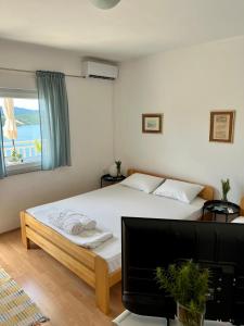 a bedroom with a bed with a television and a window at Guest House Life in Neum