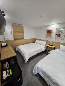 a hotel room with two beds and a desk at T hotel in Seoul