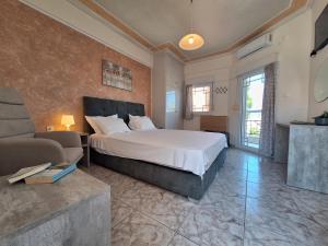 a bedroom with a large bed and a couch at Stella Maris sea front studios in Kanatádhika