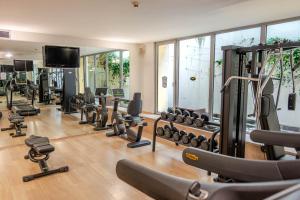 a gym with a lot of treadmills and weights at Hotel For You in Cernusco sul Naviglio