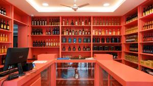 a wine tasting room with red walls and shelves of wine bottles at Hotel Lemon in Valavanūr