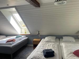 two beds in a room with two windows at Hellesbnb in Rømø
