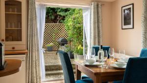 a dining room with a table and chairs and a sliding glass door at Lemon Tree Cottage in Broadway +17 photos