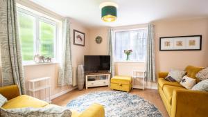 a living room with a couch and a tv at Lemon Tree Cottage in Broadway