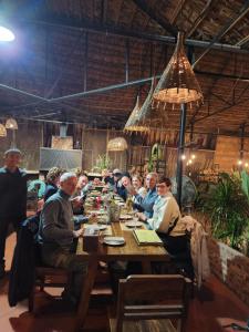 a group of people sitting around a wooden table at Choose hideaway homestay in Kỳ Vĩ