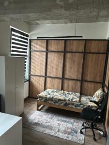 a bedroom with a bed and a chair in a room at Noclegi Kolejowa in Rybnik