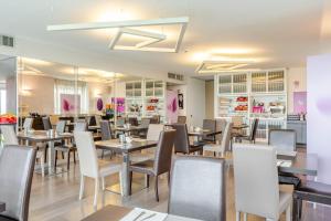 a restaurant with tables and chairs in a room at Hotel For You in Cernusco sul Naviglio