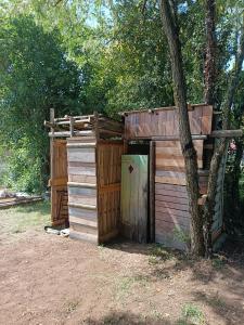 a wooden out house with a tree next to it at Le CLOS SUZANNE in Vesaignes-sous-Lafauche