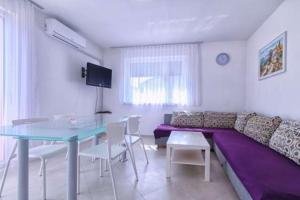 een woonkamer met een paarse bank en een tafel bij Apartments Dragica 927 in Medulin