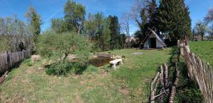 a yard with a wooden fence and a house at Le CLOS SUZANNE in Vesaignes-sous-Lafauche