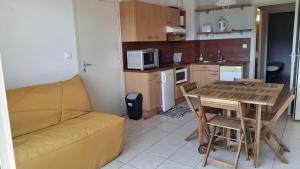 a living room with a couch and a table and a kitchen at Les Abeilles in Trébas +2 photos