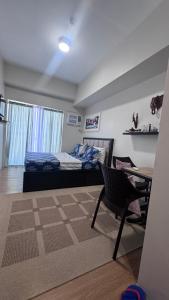 a bedroom with a bed and a desk and a chair at Eve's Condo in Cagayan de Oro