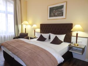 a hotel room with a large bed and a chair at Fründts Hotel in Wismar