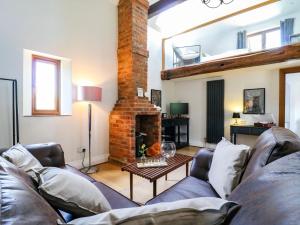 a living room with a couch and a fireplace at Barn Owl Cottage in Bedford