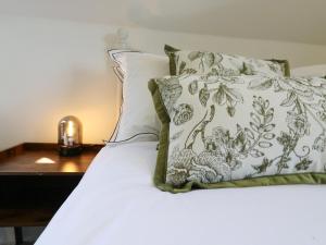 a bed with a pillow and a table with a lamp at Barn Owl Cottage in Bedford