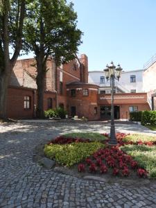 a courtyard with flowers and a street light at Fründts Hotel in Wismar