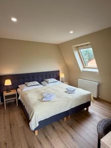 a bedroom with a large bed with two towels on it at Dworek Zielińskich-Domki, Apartamenty, Podgrzewany basen, Parking in Rewal +169 photos