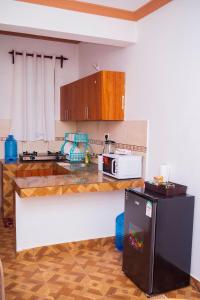 a kitchen with a counter with a microwave and a refrigerator at MERED Haven Studio in Kilifi
