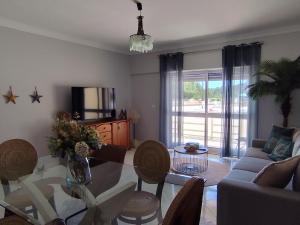 a living room with a glass table and chairs at BEACH house in Sesimbra