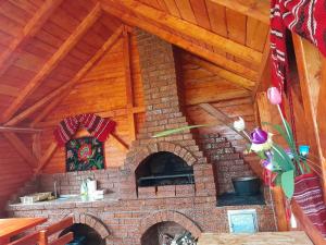 a brick oven in a room with a wooden ceiling at Cabana Adelin in Dobreşti