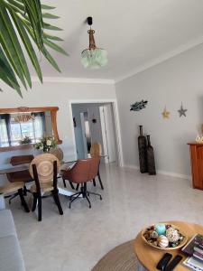 a living room with a table and chairs and a piano at BEACH house in Sesimbra