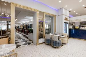 a restaurant with tables and chairs in a building at Ramada by Wyndham Shymkent in Shymkent