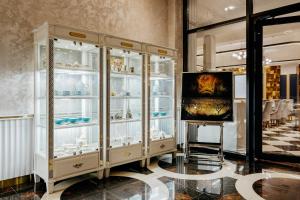 a white cabinet with glass doors and a tv in a room at Ramada by Wyndham Shymkent in Shymkent