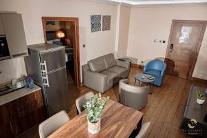 a kitchen and living room with a table and a couch at Hotel La Falaise Bonapriso in Douala
