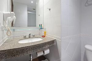 a bathroom with a sink and a mirror at Slim Hotel Curitiba Alto da XV in Curitiba